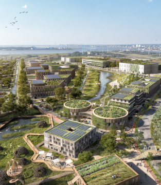 Eine große Fläche mit Naturschutzflächen, begrünten Gebüden und Weideland. Im Hintergrund ist die Stadt Bremerhaven zu sehen. | © Reinventing Society & loomn, Foto: Dennis Vogt