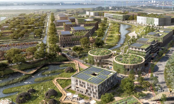 Eine große Fläche mit Naturschutzflächen, begrünten Gebäuden und Weideland. Im Hintergrund ist die Stadt Bremerhaven zu sehen. | © Reinventing Society & loomn, Foto: Dennis Vogt, Architekturvorlage: Tim David Müller-Zitzke