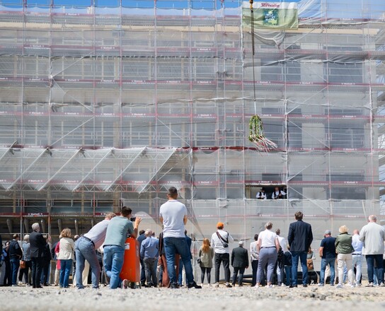 Richtfest Gründungszentrum | © Magistratspressestelle / Arnd Hartmann Viele Menschen stehen mit dem Rücken zur Kamera und schauen auf ein Gebäude | © Magistratspressestelle / Arnd Hartmann